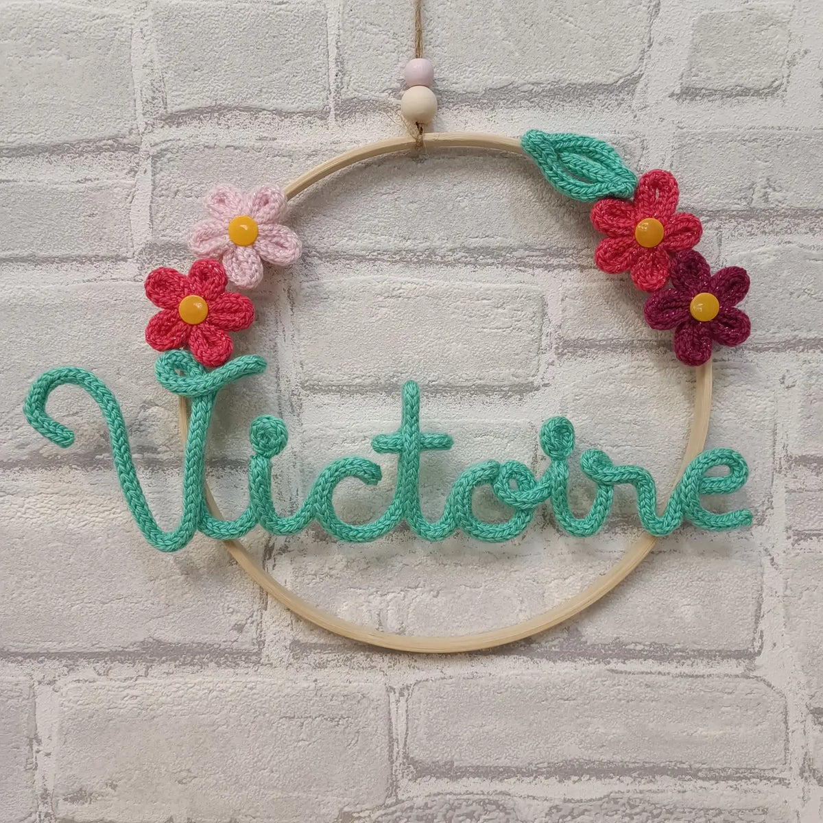 Prénom en tricotin Victoire avec fleurs