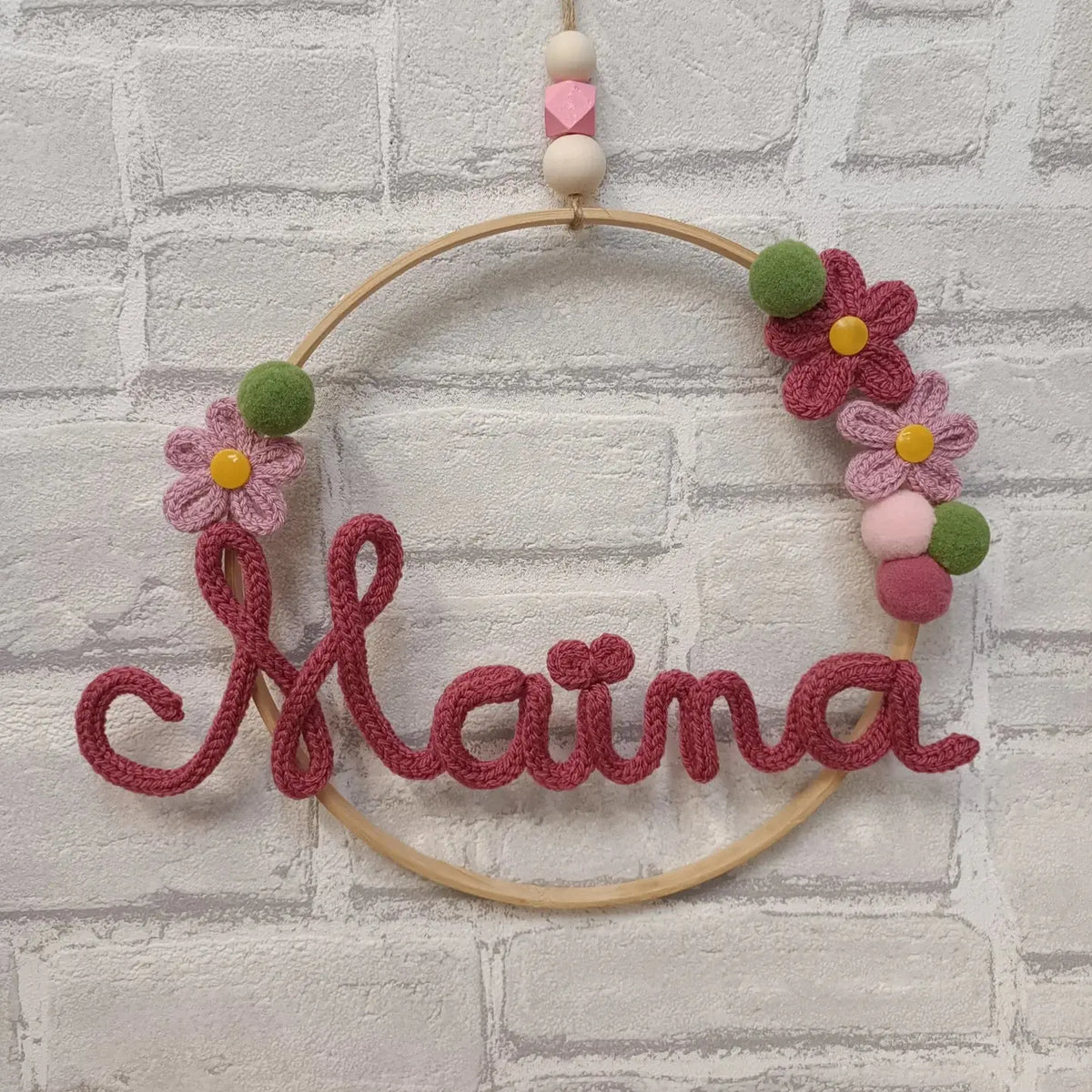 Prénom en tricotin Maïna rose avec des fleurs