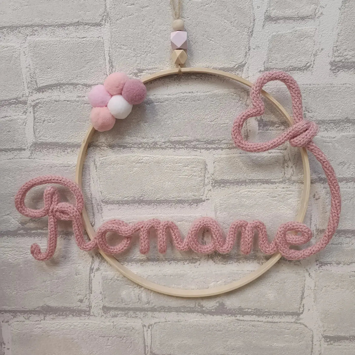 Prénom en tricotin Romane avec un coeur couleur rose